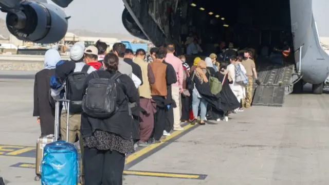 Evacuees boarding a C-17 military plane at Kabul airport