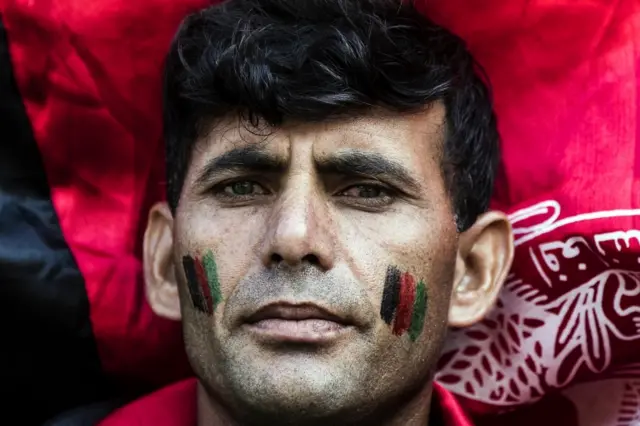 A man looks on as activists demonstrate in solidarity with the people of Afghanistan, in Rome, Italy,