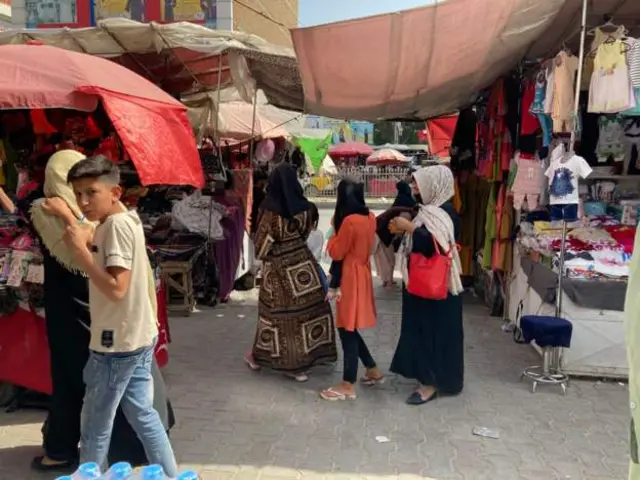 People walk in a market in Kabul