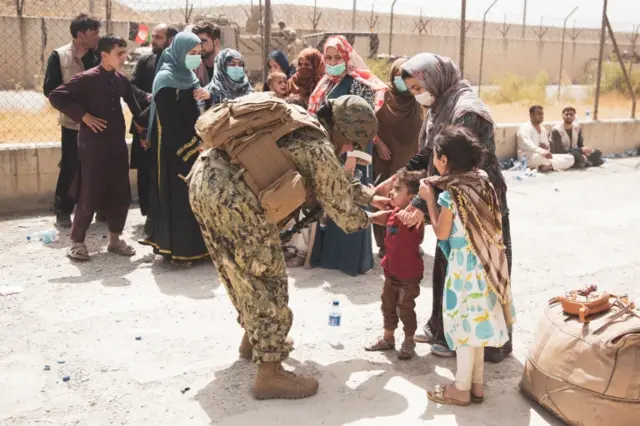 A US soldier checks a child arriving at Kabul airport