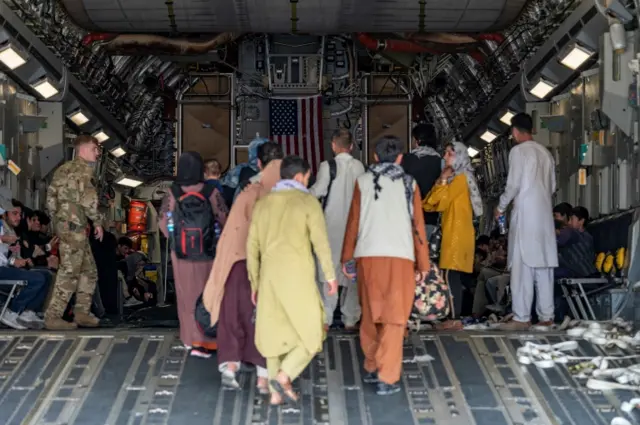 Evacuees board a US military aircradt in Kabul