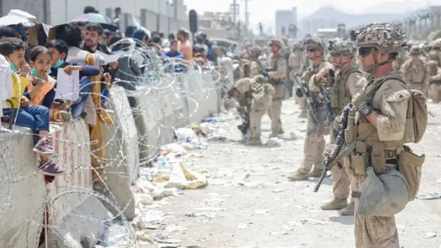 U.S. Marines with Special Purpose Marine Air-Ground Task Force - Crisis Response - Central Command, provide assistance during an evacuation at Hamid Karzai International Airport, in Kabu