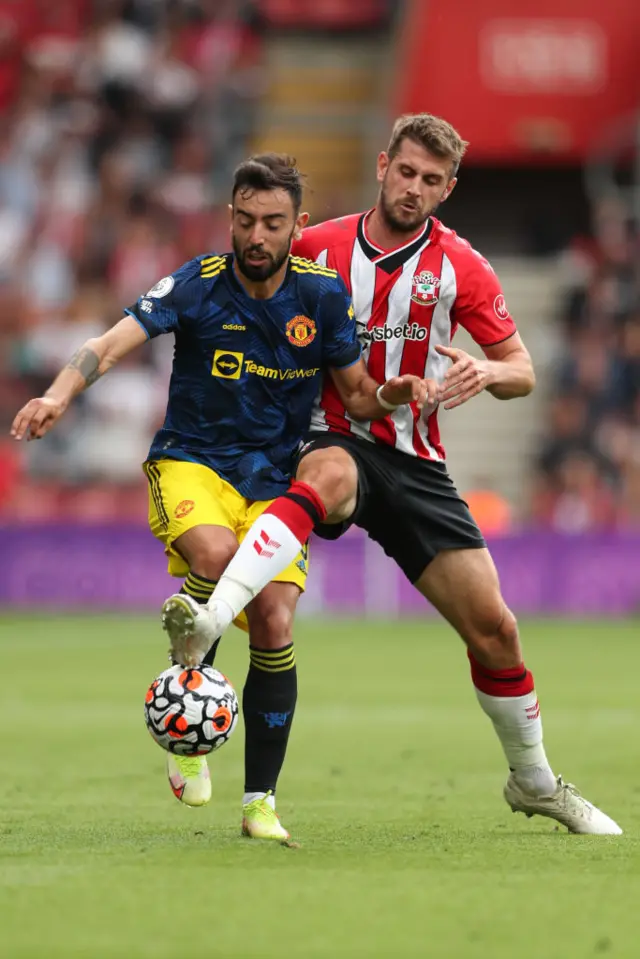 Jack Stephens steps in front of Bruno Fernandes