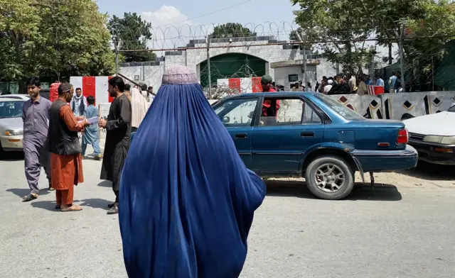 A woman in a burqa waits outside the Pakistani embassy in Kabul.