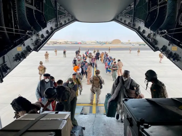 Afghans and Spanish citizens queuing for Spanish military plane