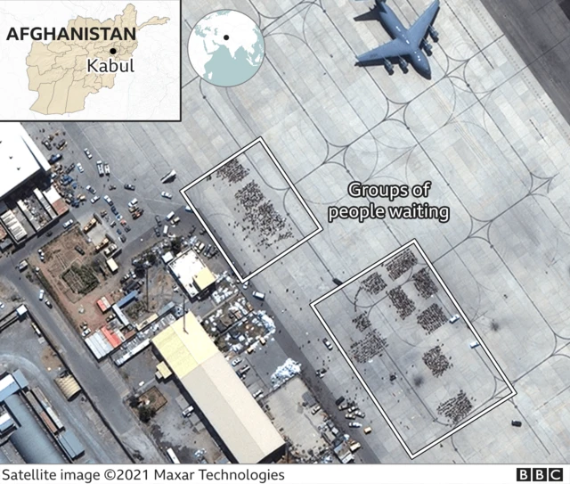 A satellite photo of the runway at Kabul airport showing large groups waiting to board evacuation flights.