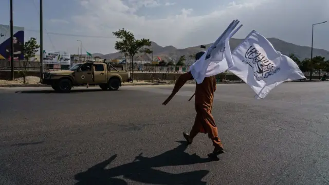 Man carries Taliban flags