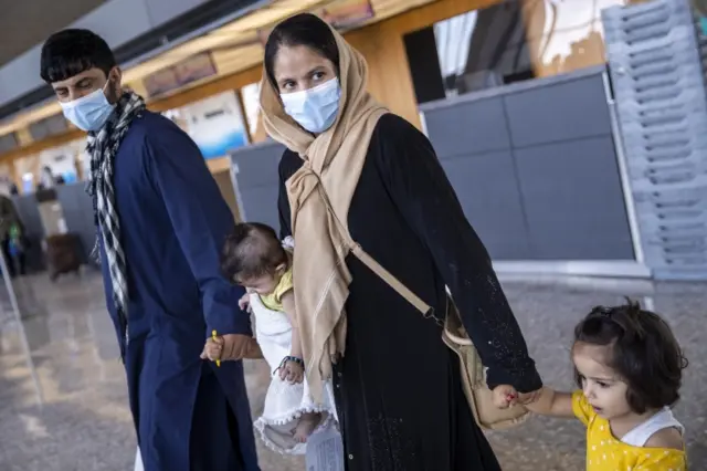 An Afghan family evacuated from Kabul walk at Washington Dulles International Airport in Chantilly, Virginia. Photo: 24 August 2021