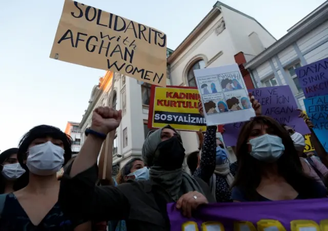 Activists hold placards during a demonstration in support of Afghan women