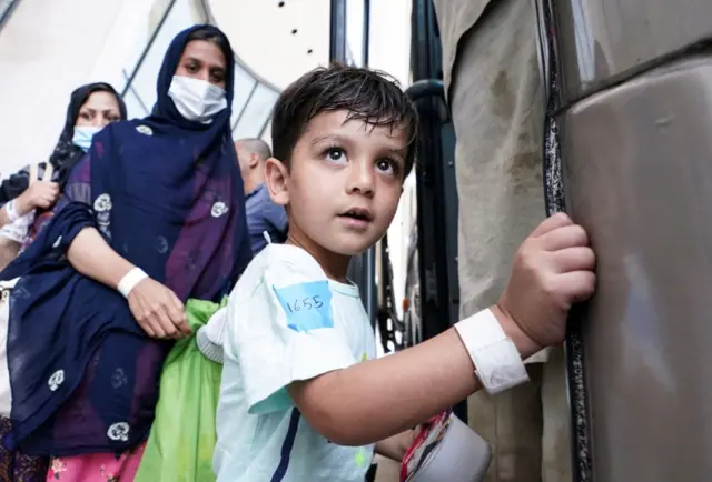 An Afghan boy boards a bus taking refugees to a processing centre upon arrival at Dulles International Airport in Dulles, in the US state of Virginia. Photo: 25 August 2021