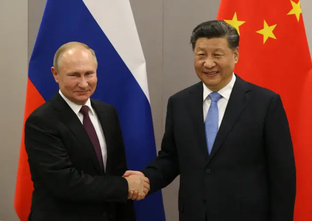 Xi Jinping shakes hands with Vladimir Putin in 2018