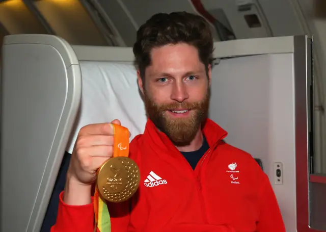 Jon-Allan Butterworth holds up his gold medal from Rio 2016