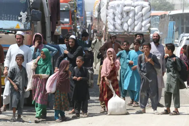 Afghan people wait at Torkham border crossing to enter Pakistan on August 24, 2021, in Torkham, Pakistan