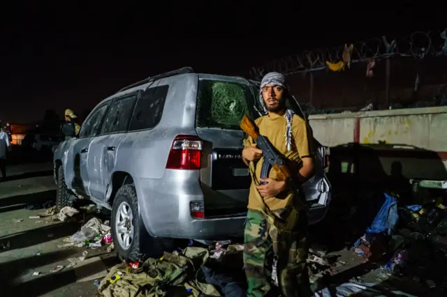 A Taliban fighter guards a checkpoint outside the airport in Kabul