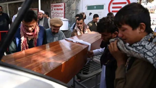 Relatives load in a car the coffin of a victim of the August 26 twin suicide bombs