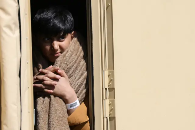 An evacuee from Afghanistan looks out from a tent after his arrival today at Ramstein Air Base, 26 August 2021