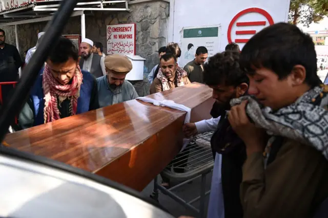 Relatives load in a car the coffin of a victim of the August 26 twin suicide bombs