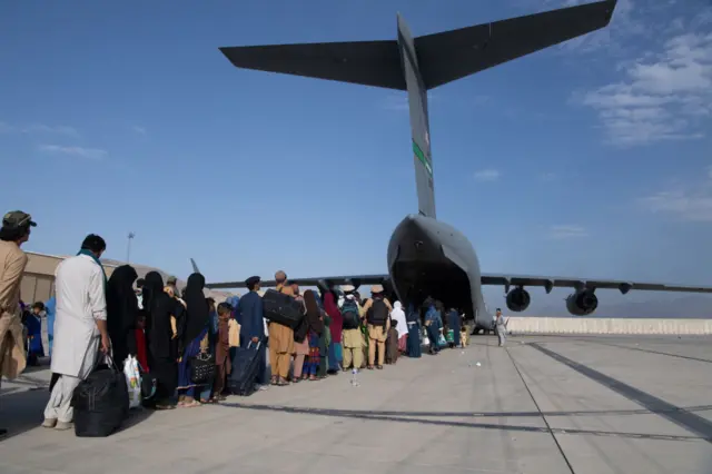 US Central Command handout photo of Afghans boarding a US plane at Hamid Karzai International Airport (HKIA) on August 24, 2021 in Kabul, Afghanistan