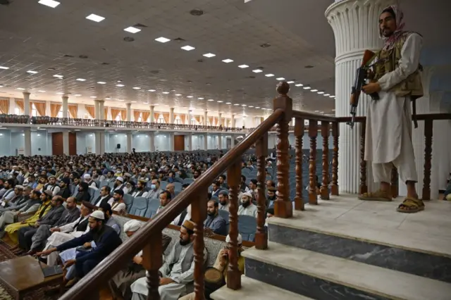 A Taliban fighter stands guard as Talibans acting Higher Education Minister Abdul Baqi Haqqani (not pictured) addresses a gathering during a consultative meeting on Taliban's general higher education policies at the Loya Jirga Hall in Kabul on August 29, 2021