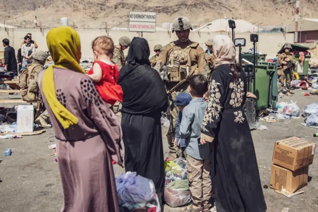 U.S. Marines with the 24th Marine Expeditionary Unit (MEU) process evacuees as they go through the Evacuation Control Center (ECC) during an evacuation at Hamid Karzai International Airport