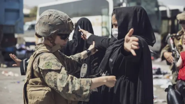 US forces search a woman before evacuation