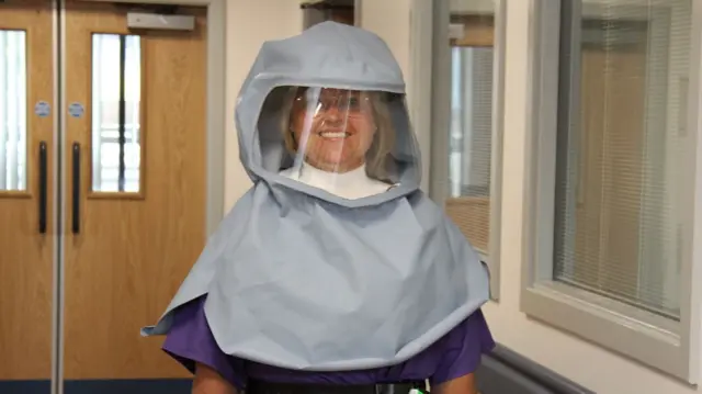 Matron Sally Young wearing a new full-face protective hood