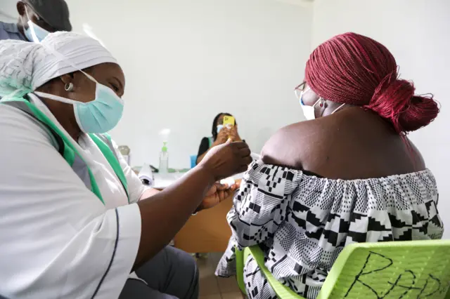 A medical worker injects the AstraZeneca"s COVID-19 vaccine to a woman at the Nationa Hospital in Abuja