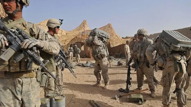 US troops put on equipment at a base