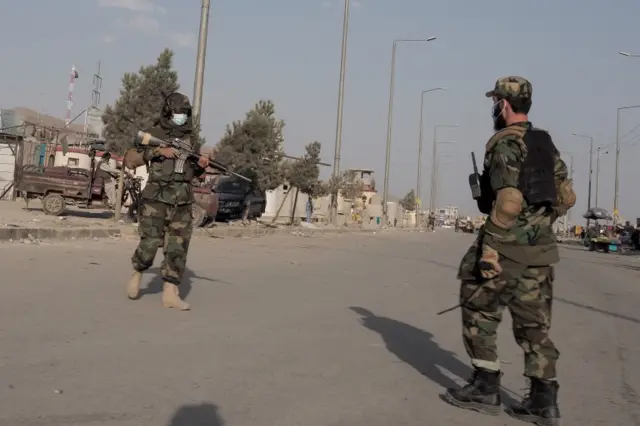 Taliban members patrol the outside of the airport in Kabul