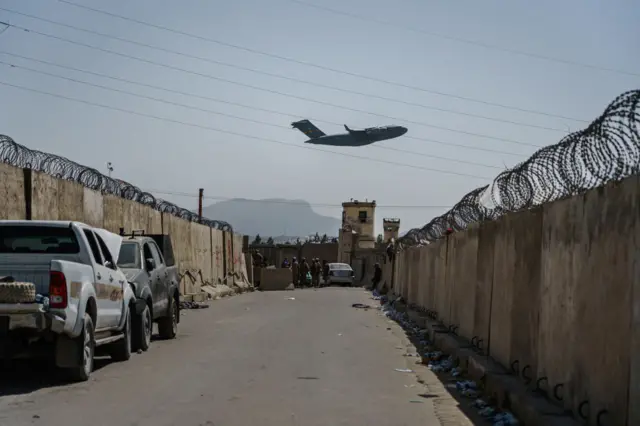 A C-17 Globemaster takes off as Taliban fighters secure the outer perimeter of Kabul airport