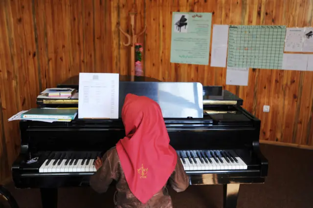 A young orphan girl plays the piano in a music class in the Afghan National Institute of Music on October 19, 2011 in Kabul, Afghanistan.