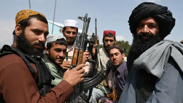 Taliban fighters sit on the back of a pick-up truck at the airport in Kabul on August 31, 2021, after the US has pulled all its troops out of the country