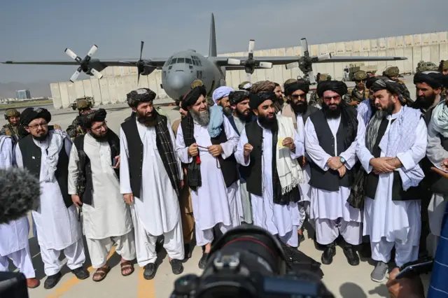 Taliban spokesman Zabihullah Mujahid (centre, with shawl) at Kabul airport. Photo: 31 August 2021