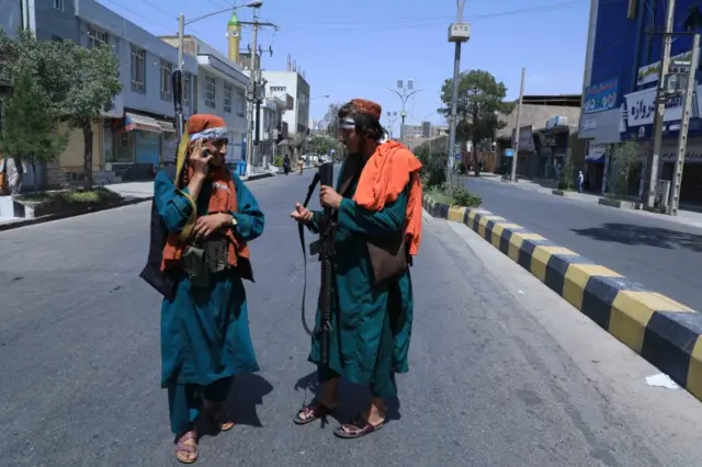 Taliban stand guard as Shiite Muslims attend a mourning procession during Ashura, in Herat, Afghanistan, 19 August 2021.