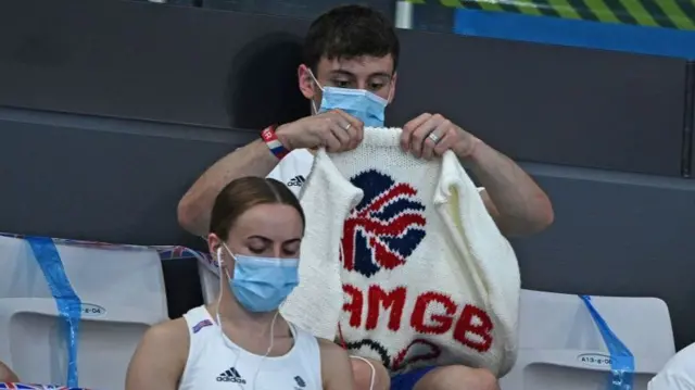 Tom Daley knitting in the stands