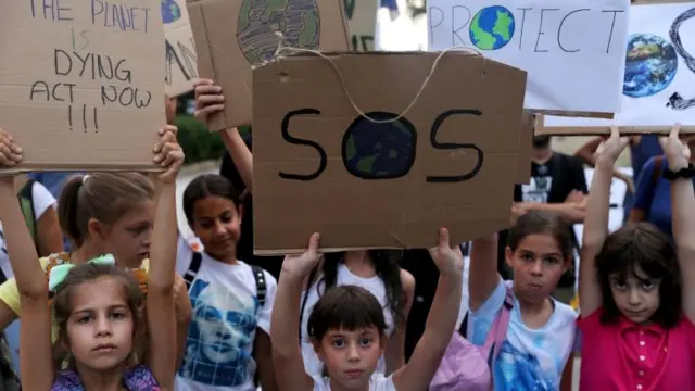 Children holding climate placards