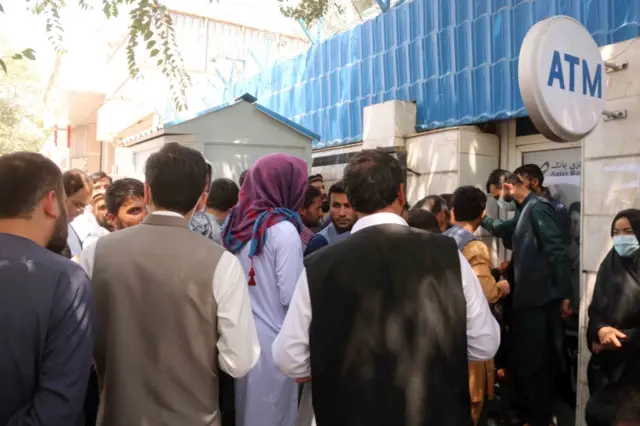 Afghans gather outside a closed bank in Kabul. Photo: August 2021