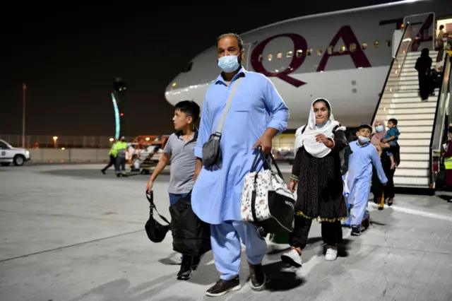 Passengers leave a Qatar Airlines plane arriving from Kabul, Afghanistan, the first international commercial flight since the US withdrawal from Afghanistan, in Doha, Qatar, on 9 September 2021