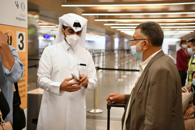 An immigration member of staff checks the passports of passengers arriving on a Qatar Airways plane from Kabul, Afghanistan, the first international commercial flight since the US withdrawal from Afghanistan, in Doha, Qatar, on 9 September 2021