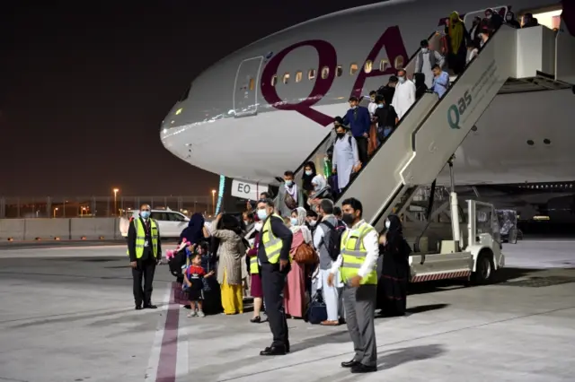 Passengers disembark a Qatar Airways plane arriving from Kabul, Afghanistan, in Doha, Qatar, on 9 September 2021