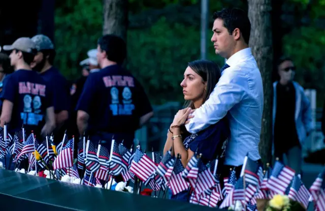 Katie Mascali is comforted by her fiance Andre Jabban as they stand near the name of her father Joseph Mascali, with FDNY Rescue 5, during ceremonies on September 11, 2021