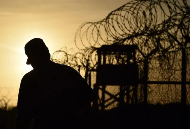 A silhouette of a man pictured by a US military base in Guantanamo Bay, Cuba