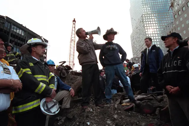 Standing atop rubble with retired New York City firefighter Bob Beckwith, President George W Bush rallies firefighters and rescue workers during an impromptu speech at the site of the collapsed World Trade Center in New York City, New York, September 14, 2001. Image courtesy National Archives. (Photo via Smith Collection/Gado/Getty Images).