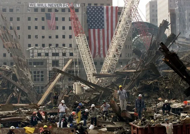 Rescue workers search through the wreckage of the World Trade Center, 24 September 2001, in New York.