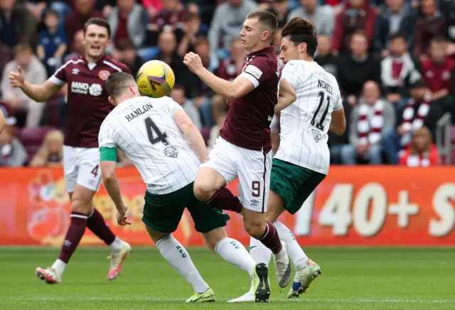 Hearts' Ben Woodburn (centre) is tackled by Hibernian's Paul Hanlon and Joe Newell during a cinch Premiership match between Heart of Midlothian and Hibernian at Tynecastle on September 12, 2021, in Edinburgh