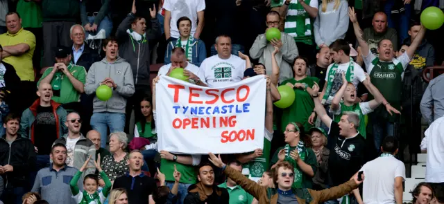 Hibs fans hold up a banner taunting their rivals Hearts' financial plight