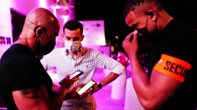 Security checking a QR code outside a nightclub