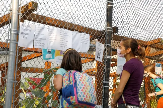 Children and adults in masks outside a school in Brooklyn, New York