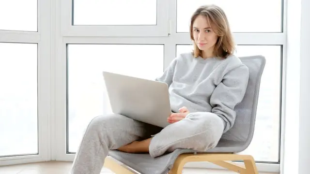 A stock picture of a woman working from home in a tracksuit