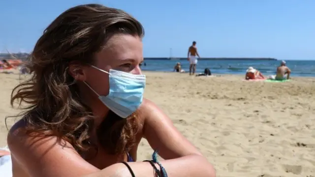 Woman in mask on beach